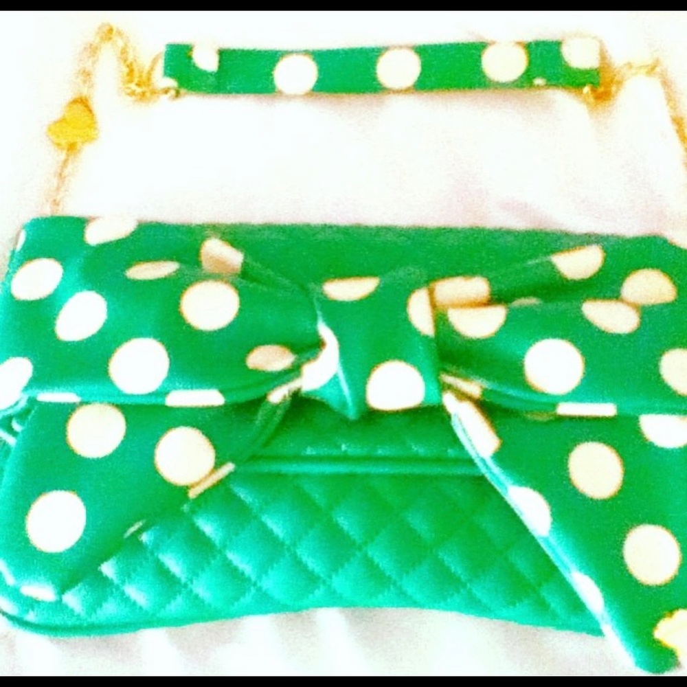 Green and white polka dot leather Betsy Johnson purse with bow and strap.